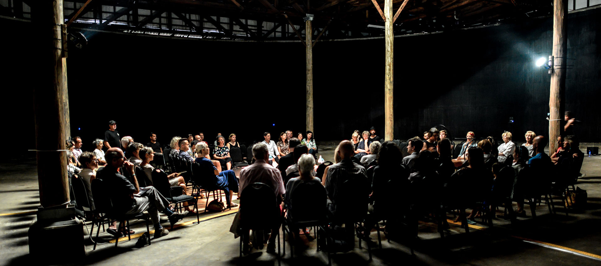 A group of people seated in a circle of chairs inside the Fuel Tank venue at Georges Heights in Headland Park, Mosman.