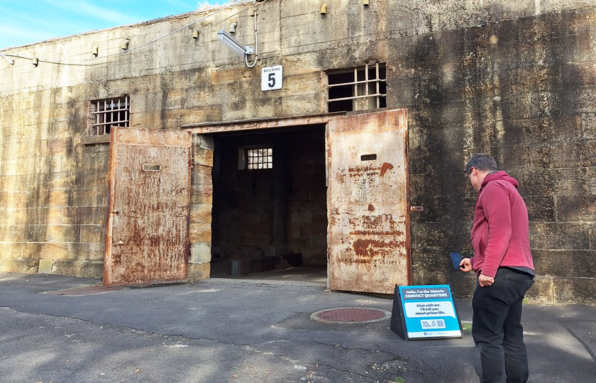 Man scanning a blue talking object sign outside of Cockatoo Island's Convict Precinct.