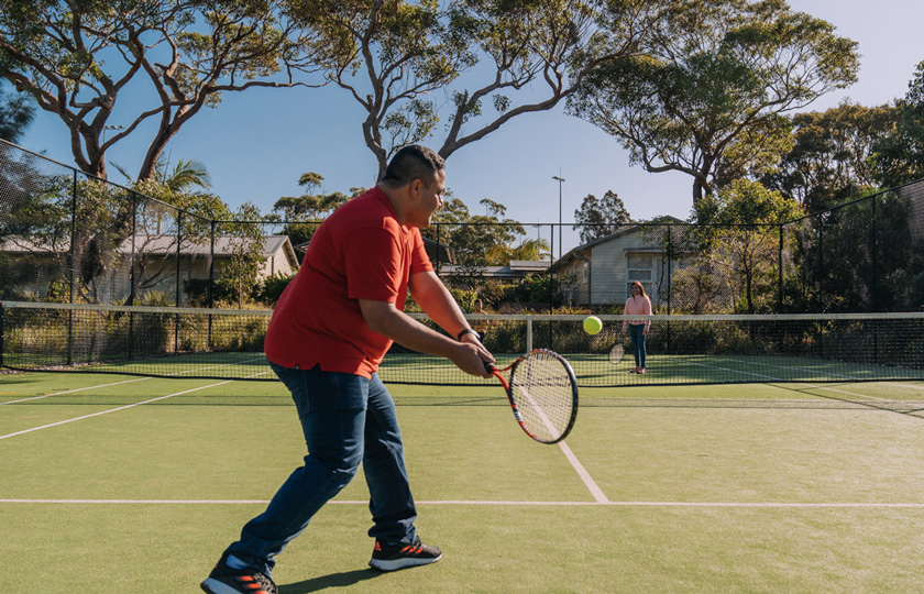 Husband and wife playing a game of tennis on an outdoor court in Middle Head, Headland Park, Mosman.