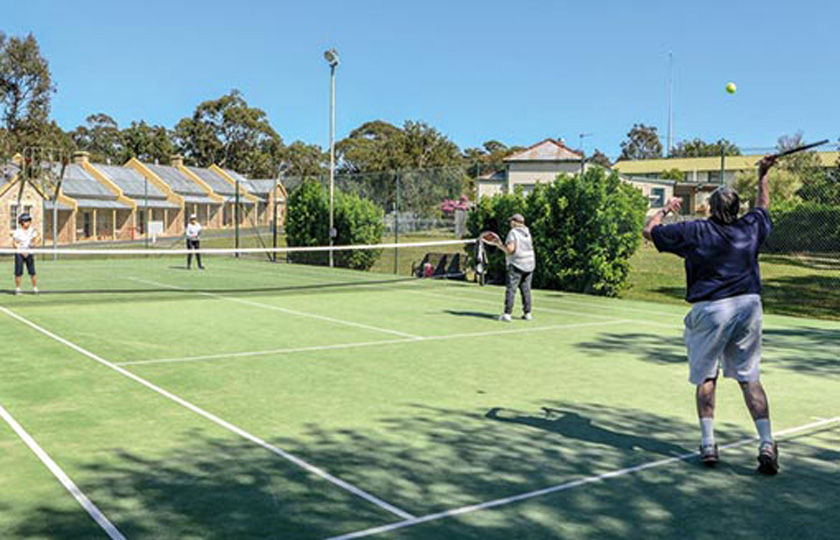 People playing a game of tennis on an outdoor court in Georges Heights, Mosman.