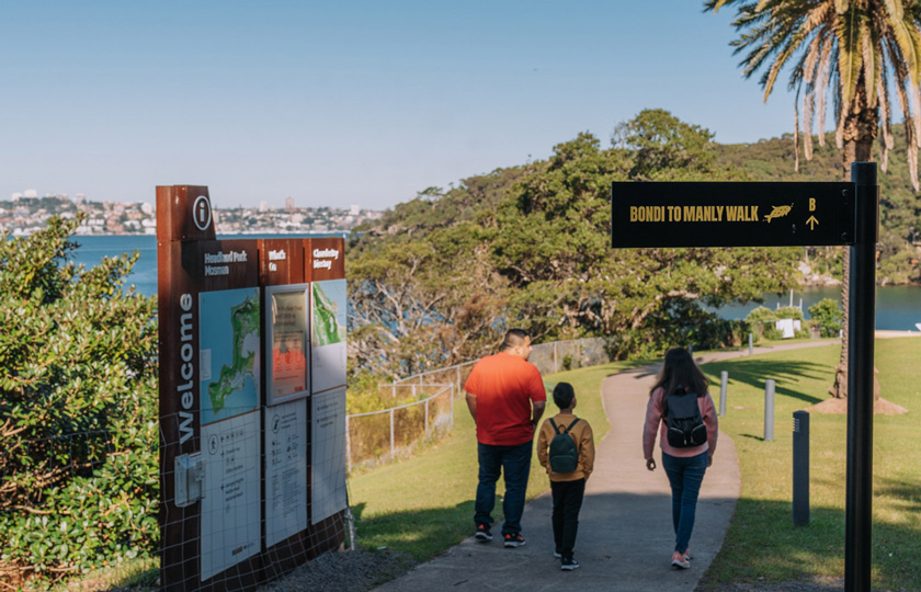 Family strolling along the Bondi to Manly walk pathway at Chowder Bay in Headland Park, Mosman.