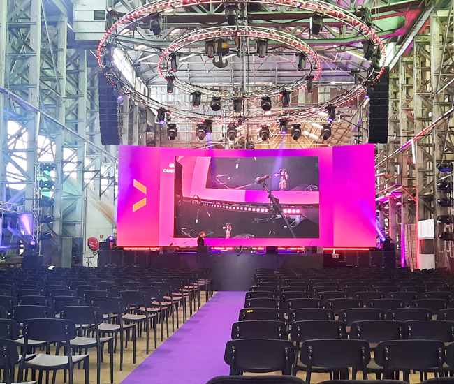 Private event set up with chairs and a large TV screen inside Cockatoo Island's Turbine Shop.